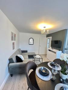 een woonkamer met een bank en een tafel bij Modern and spacious flat in Longbridge