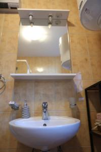 a white sink in a bathroom with a mirror at Apartman 1 Zlaja Vlašić in Vlasic