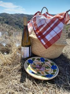 a plate and a bottle of wine and a basket at Natur Amêndoa 