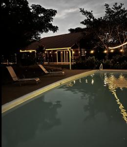 a swimming pool in front of a house at night at Las cabañas del Francés in Alto Boquete