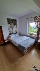 a bed in a room with a window at Góralski domek na szczycie in Zwardoń