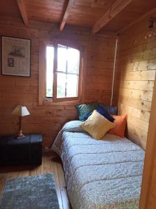 um quarto com uma cama num chalé de madeira em Cabana Monte do Castro em Porto do Son