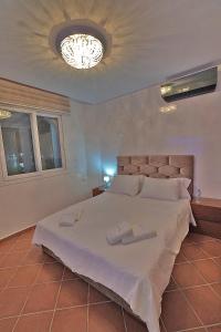 een slaapkamer met een groot wit bed en een kroonluchter bij InHome Apartment in Cabo Negro