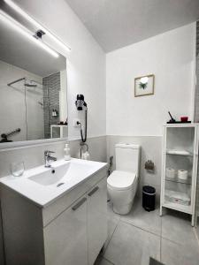 a white bathroom with a sink and a toilet at Casa BIMBA Agaete con terraza y ducha exterior in Agaete