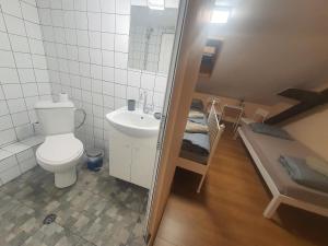 a bathroom with a toilet and a sink and a bed at HANCHO - KAPANA CENTER PLOVDIV in Plovdiv
