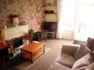 a living room with a couch and a tv at country retreat by the sea in Bessingby