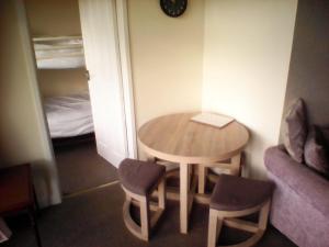 a small table and chairs in a room with a bed at country retreat by the sea in Bessingby