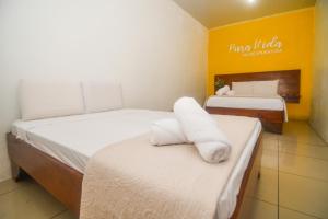 ein Hotelzimmer mit 2 Betten und Handtüchern darauf in der Unterkunft Puntarenas Bed & Coffee by Aldea in Puntarenas
