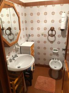 La salle de bains est pourvue d'un lavabo et de toilettes. dans l'établissement Un nido accogliente con vista, à Verrand