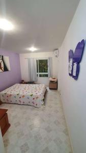 a small bedroom with a bed and a window at Apartamento 2 suítes Frente à Praia de Camboinhas - Niterói - RJ - Brasil in Niterói