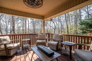 un porche cubierto con sillas y mesa en My Happy Place-Games, Lakeside, & Scenery Views, en Hot Springs