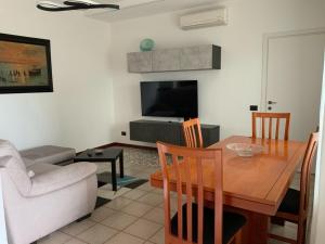sala de estar con mesa de comedor y TV en La Casetta, en Pombia