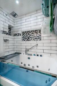 y baño de azulejos blancos con bañera. en My Happy Place-Games, Lakeside, & Scenery Views, en Hot Springs