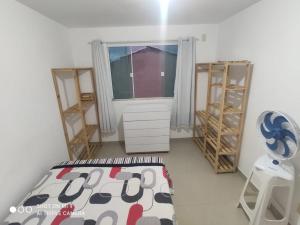 a bedroom with a bed and a window and shelves at Apto Praia Inteiro Florestas das Gaivotas in Rio das Ostras