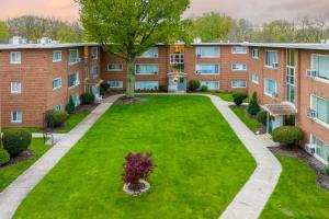 um edifício de apartamentos com um relvado verde em frente em Georgetown Villas 3-2c Close to Cleveland Airport and Fairview Hospital ideal for long stays! em Fairview Park