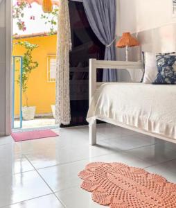 a bedroom with a bed and a window and a rug at La Estacion Hostel - Pipa in Pipa