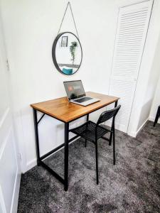 a desk with a laptop on it with a chair at No 7 - Bright, Spacious 3 Bed Home with Parking & WiFi in Huyton +13 photos