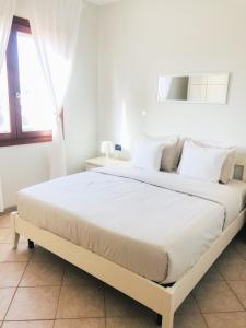 a white bedroom with a large bed with white pillows at Boavista Beach Apartment in Sal Rei