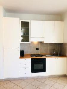 una cocina con armarios blancos y horno negro en Boavista Beach Apartment en Sal Rei