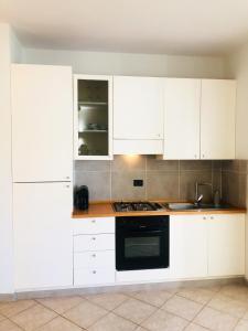 a kitchen with white cabinets and a black oven at Boavista Beach Apartment in Sal Rei