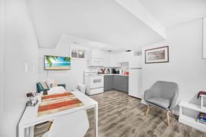 un soggiorno bianco con tavolo e sedia di 1 Bedroom Studio Close To University Of Guelph a Guelph