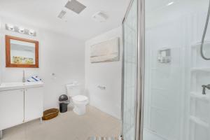 a white bathroom with a shower and a toilet at 1 Bedroom Studio Close To University Of Guelph in Guelph