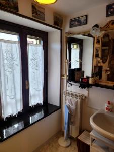 a bathroom with a sink and a window with curtains at La Torretta a 10 minuti dal lago di Garda in Castiglione delle Stiviere