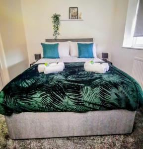 No 7 - Bright, Spacious 3 Bed Home with Parking & WiFi في هويتون: غرفة نوم بسرير كبير مع بطانية خضراء