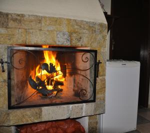 a brick fireplace with a fire in it at Pousada Encanto da Serra in Monte Verde