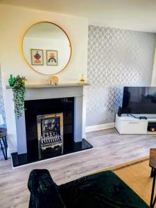 a living room with a fireplace and a mirror at No 7 - Bright, Spacious 3 Bed Home with Parking & WiFi in Huyton