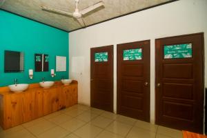 ein Badezimmer mit zwei Waschbecken und zwei Türen in der Unterkunft Puntarenas Bed & Coffee by Aldea in Puntarenas