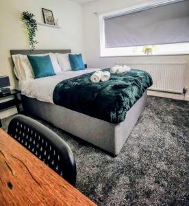 a bedroom with a bed with two towels on it at No 7 - Bright, Spacious 3 Bed Home with Parking & WiFi in Huyton