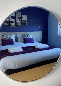 1 dormitorio con 1 cama grande y espejo redondo en The Woolpack Inn, en Kettering