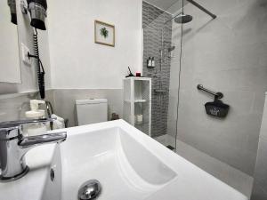 y baño blanco con lavabo y ducha. en Casa BIMBA Agaete con terraza y ducha exterior, en Agaete