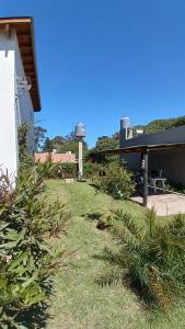 um quintal com relva e plantas e uma casa em Casuarinas em La Estafeta