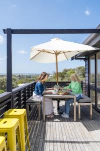 two women sitting at a table under an umbrella at Salty Breeze in Saint Andrews Beach