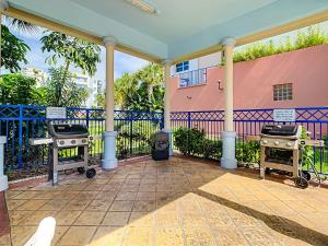 a patio with two bbq grills in front of a fence at Estuary Views Close to Pool Amenities Walk to Beach 9-505 in New Smyrna Beach