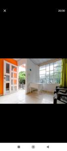 ein Wohnzimmer mit einem großen Fenster und einem Tisch in der Unterkunft Hostal Cartagena Beach in Cartagena de Indias