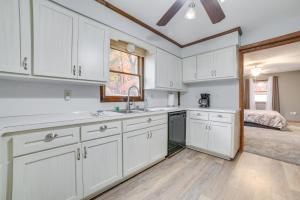 a kitchen with white cabinets and a window and a bed at Houghton Lake Vacation Rental - Walk to the Water! in Houghton Lake +19 photos