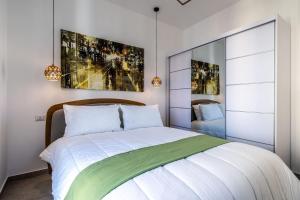 Un dormitorio con una cama blanca con una manta verde. en [Navigli-Duomo] Sweet22 Luxury OpenSpace, en Milán