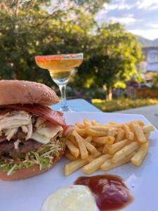 a plate with a sandwich and french fries and a drink at Green Door San Gil in San Gil