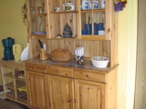 einen Holzschrank in einer Küche mit Küchenutensilien in der Unterkunft Ferienwohnung Bömitz in Bömitz