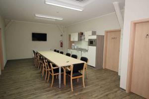 a conference room with a table and chairs and a kitchen at Kutterfisch Kajüten direkt im Stadthafen in Sassnitz