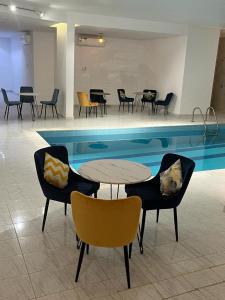 a swimming pool with chairs and tables and a table and chairs at شقق جدة دستنيشن in Jeddah