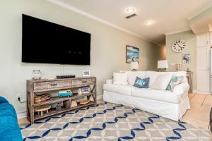 a living room with a white couch and a flat screen tv at Dauphin Island Beach Club 106A in Dauphin Island