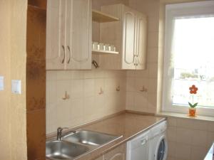 a kitchen with white cabinets and a sink and a window at Pokoje Gościnne IRGA Apartamenty in Starogard Gdański