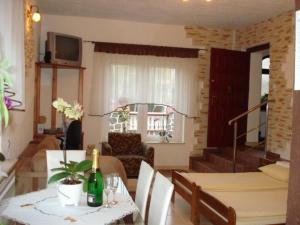 Sala de estar con mesa y botella de vino en Pokoje Gościnne IRGA Apartamenty, en Starogard Gdański