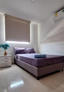 a bedroom with a bed with purple pillows at CB Apto cómodo e impecable con Aire Acondicionado in Neiva