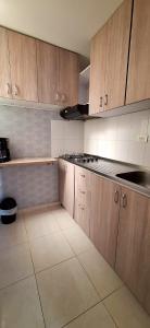 cocina con armarios de madera y encimera en CB Apto cómodo e impecable con Aire Acondicionado, en Neiva