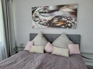 een slaapkamer met een bed met roze en witte kussens bij Alpenloft Inzell in Inzell